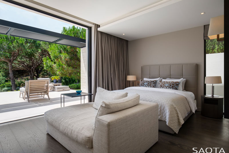 In this modern bedroom, large sliding doors open the bedroom up to the terrace, while a large chaise provides a place to relax. #ModernBedroom #BedroomDesign