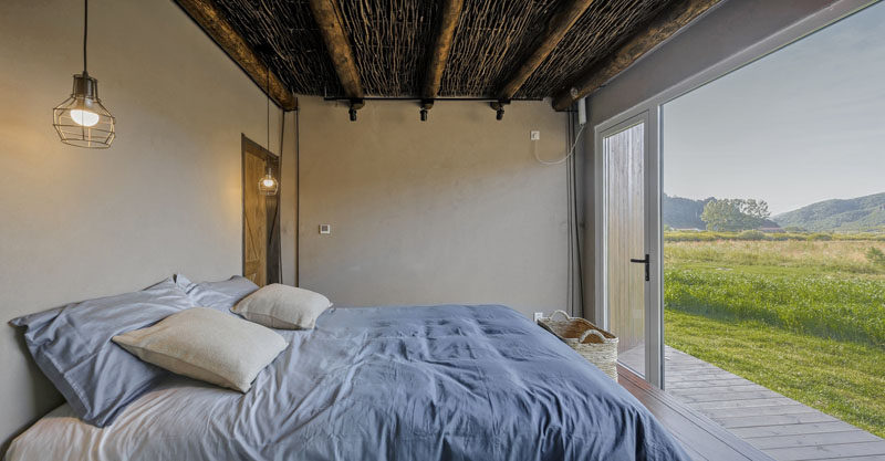 In this contemporary bedroom, a large window fills the interior with natural light and provides a picturesque view to wake up to in the morning. #ContemporaryBedroom #Windows