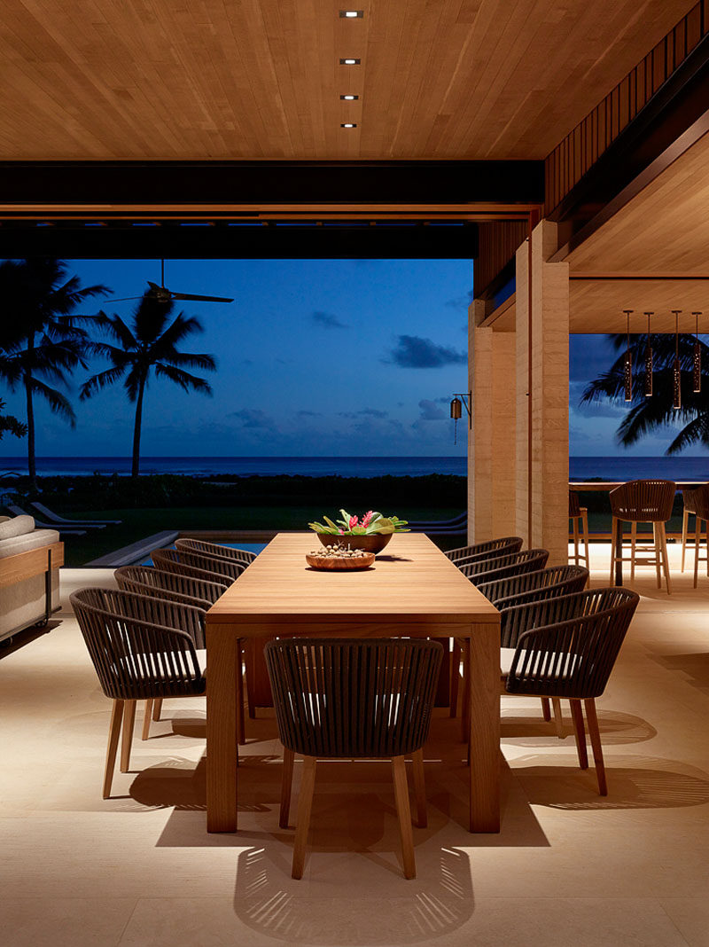 This modern and open dining area has a wood table that's surrounded by ten dining chairs, perfect for when the large family vacation together. #DiningTable #ModernDining