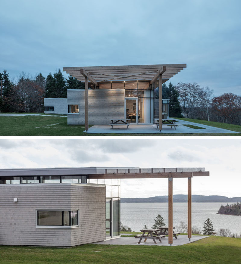 This modern house in Nova Scotia has an extended roof that creates a pergola for an outdoor entertaining space. #ModernHouse #ModernPergola