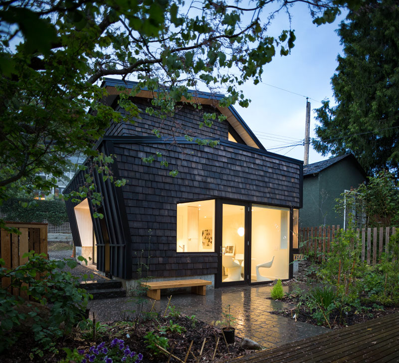 At the rear of this modern laneway house is a patio and garden that's shared with the main house. #LanewayHouse #Shingles #Patio