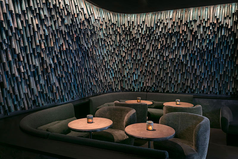Designer Raphael Navot has used oxidised copper tubes to create a unique and interesting accent wall in a restaurant within a hotel. #AccentWall #Copper #Design