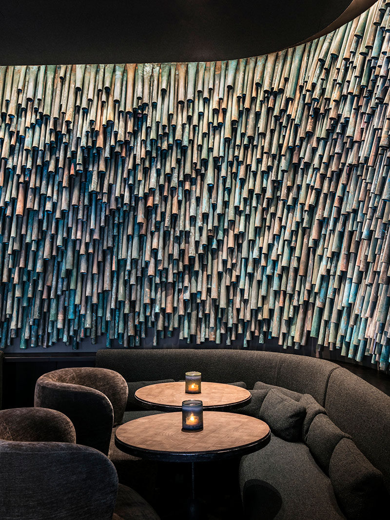 Designer Raphael Navot has used oxidised copper tubes to create a unique and interesting accent wall in a restaurant within a hotel. #AccentWall #Copper #Design