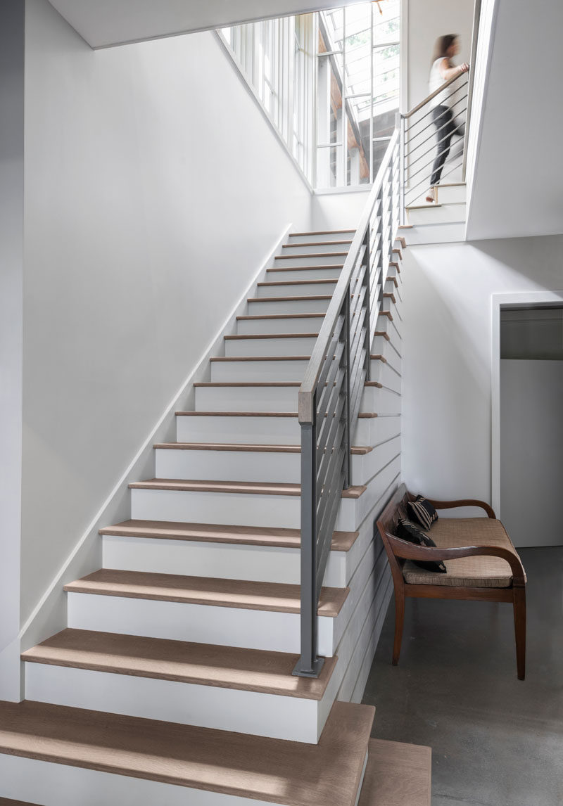 Wood and white stairs lead to the upper floor of this modern farmhouse. #Stairs #InteriorDesign