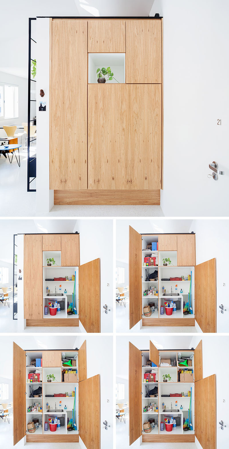 Stepping inside this apartment, you are greeted by a small white alcove with a plant that's surrounded by wood panels. Inside the panels are a variety of shelves and a small sink. #Shelving #Storage #Cabinet