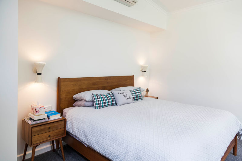 This contemporary master suite has mid-century inspired furniture while the bed looks out to the front yard. #Bedroom #MasterSuite