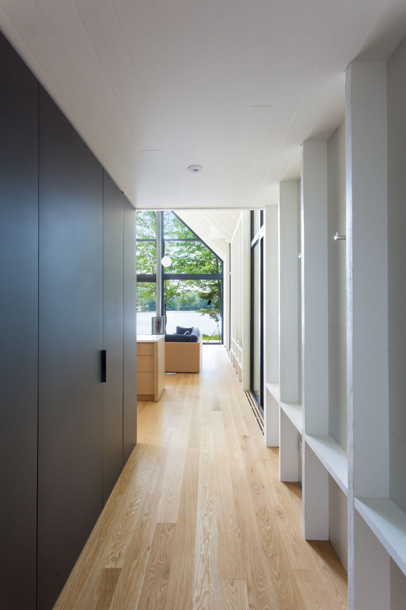 This hallway features exposed painted wood studs that act as alcoves for hanging coats. #Hallway