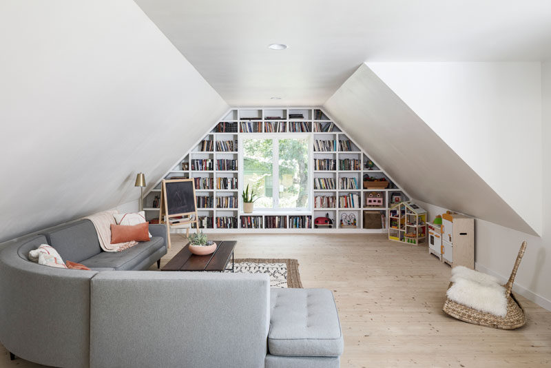This modern living room /play area has a custom designed bookshelf that wraps around the window. #Bookshelf #Window #LivingRoom