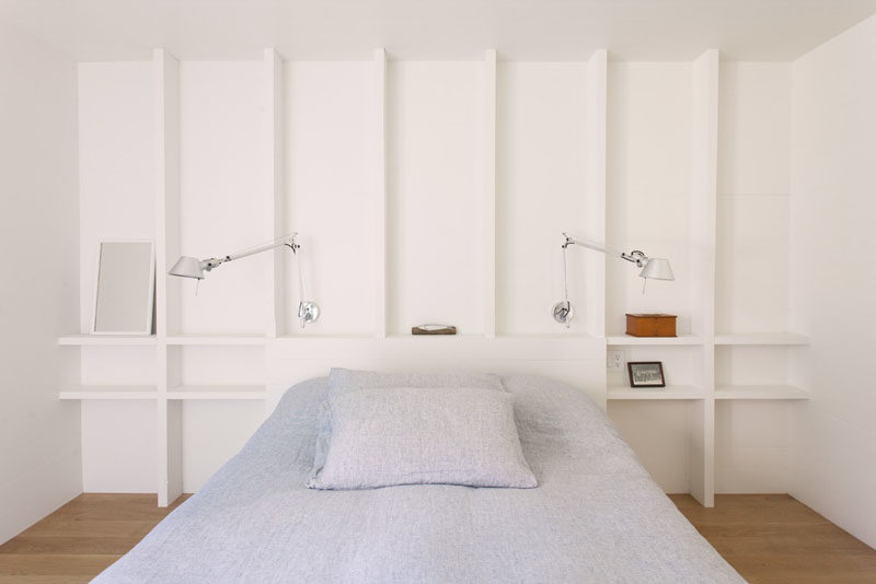 In this simple bedroom, exposed wooden studs have been painted white and act at shelving. #Shelving #BedroomDesign