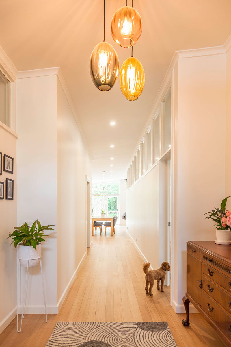 The entryway to this renovated mid-century modern home has three simple colored glass pendant lights. #Entryway #Hallway