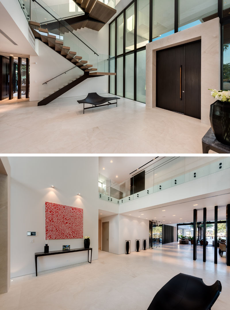 A large dark wood front door opens to a foyer with honed Portuguese limestone flooring.