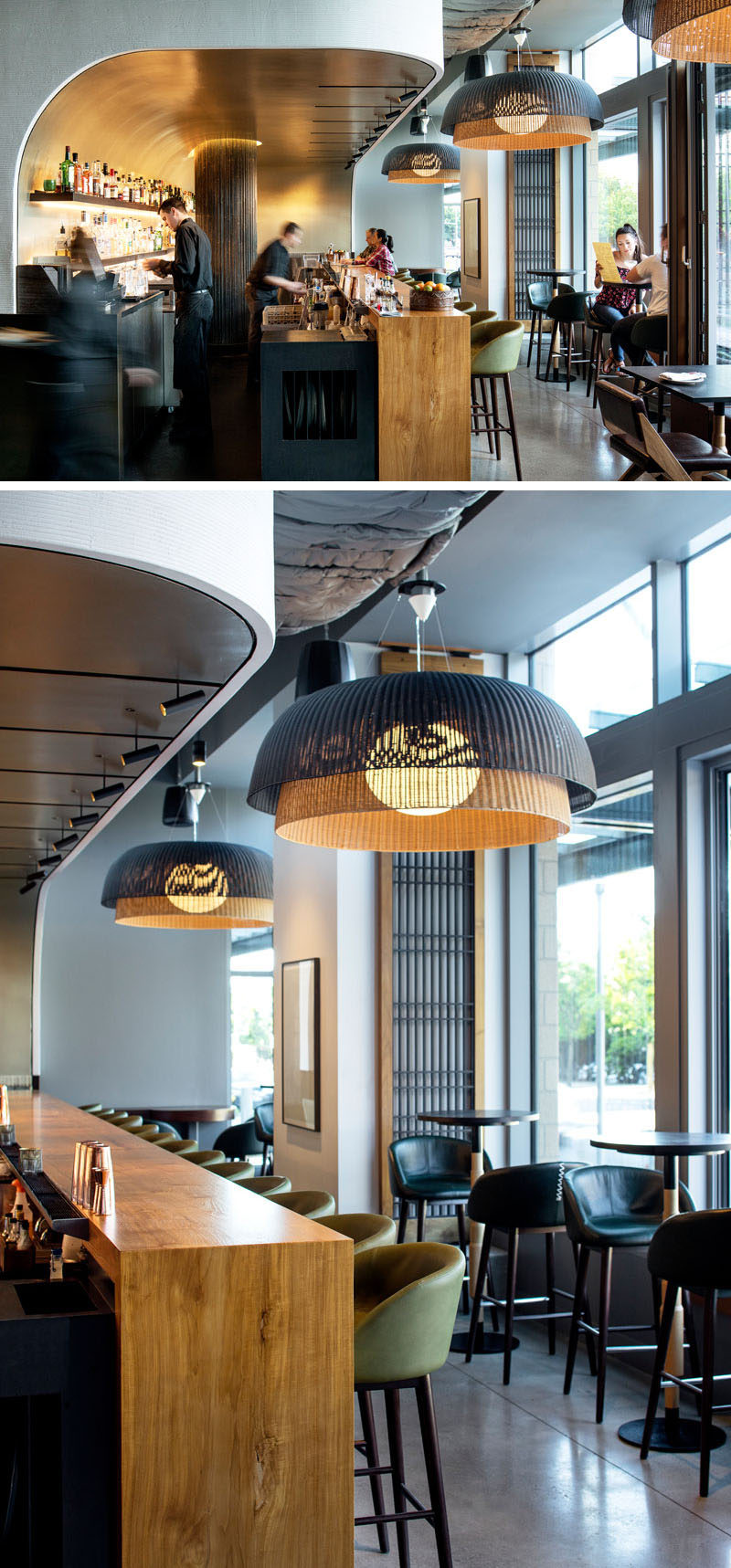 The bar in this modern restaurant appears to be set into a curved niche, that's been finished with silver leaf squares, creating a luxurious, subtly reflective backdrop. #ModernBar #RestaurantDesign