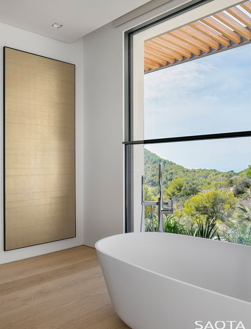 In this simple and modern bathroom, a freestanding bathtub is located in front of the window to take advantage of the views. #ModernBathroom