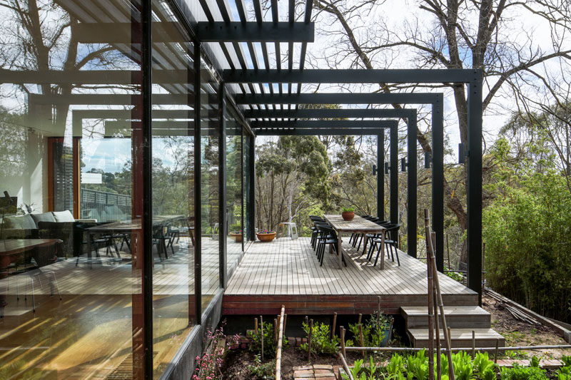 This modern house extension has a deck with a pergola. Steps lead down lead down to a small vegetable garden. #Pergola #HouseExtension