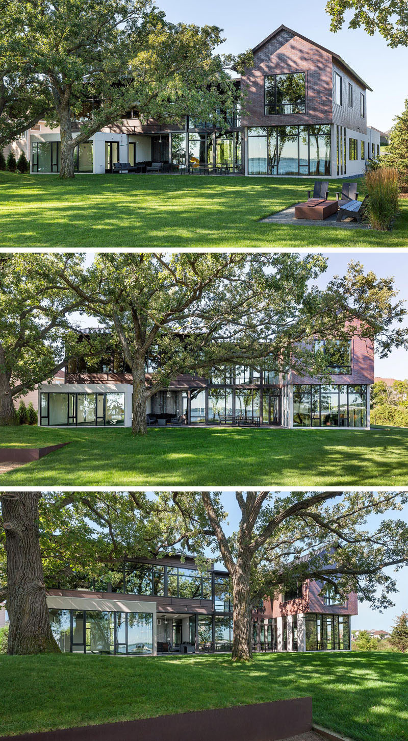 This industrial modern house uses a combination of exterior materials that include a dark bronze metal roof, a warm white stucco on the ground level, a deep auburn brick for the upper master wing, and wood planks with a black brown stain and black aluminum panel edge make up the children's wing. #ModernHouse #Architecture