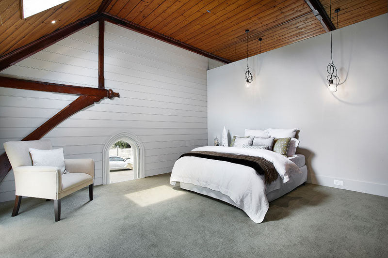 This minimalist bedroom shows of the shape of the original church and its wood ceilings and architectural details. #BedroomDesign #ChurchConversion