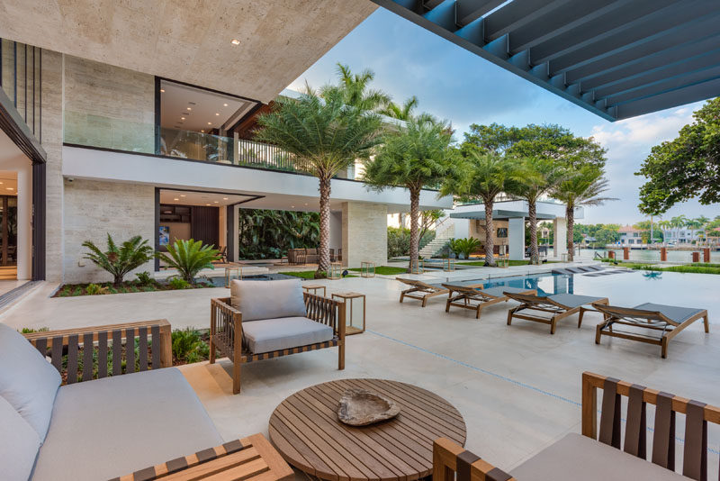 A modern backyard with a covered outdoor lounge, a large grassy area, more than 100 feet of dock space, an outdoor kitchen and cabana with rooftop access. 