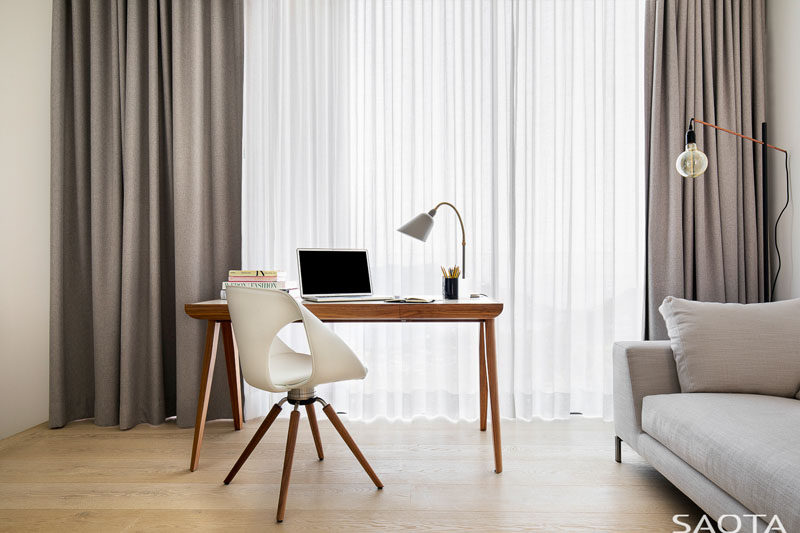 In this home office, furnishings have been kept minimal with a simple wood desk and a comfortable couch.  #ModernHomeOffice #HomeOffice