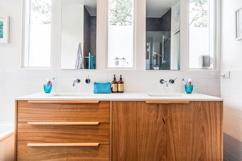 This mid-century modern inspired master bathroom has a bespoke wood vanity with handmade handles/pulls. #Bathroom #WoodVanity