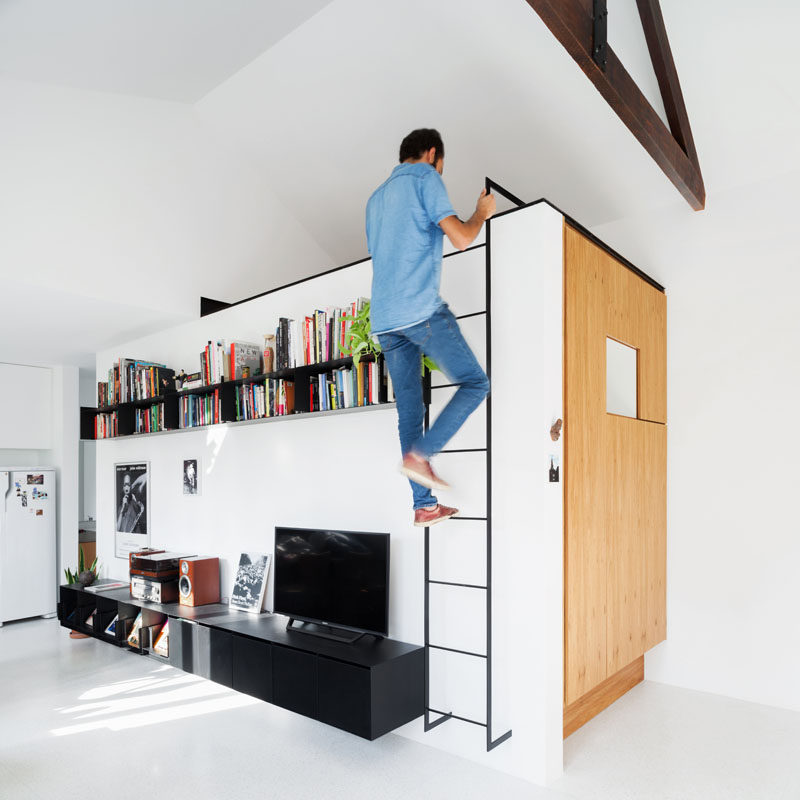 A iron ladder in this living room leads to a lofted space that can be used for storage or as an additional sitting area. #Ladder #LivingRoom #LoftedSpace