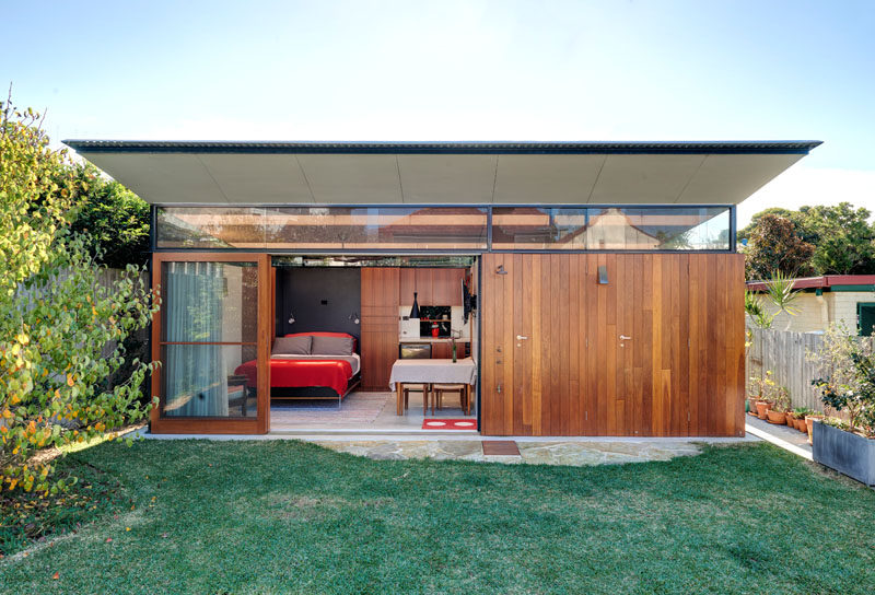 This modern backyard studio in Australia has a home office, living quarters, bathroom with laundry, an outdoor shower and a shed with an indoor/outdoor workspace. #BackyardStudio #GuestHouse #Architecture