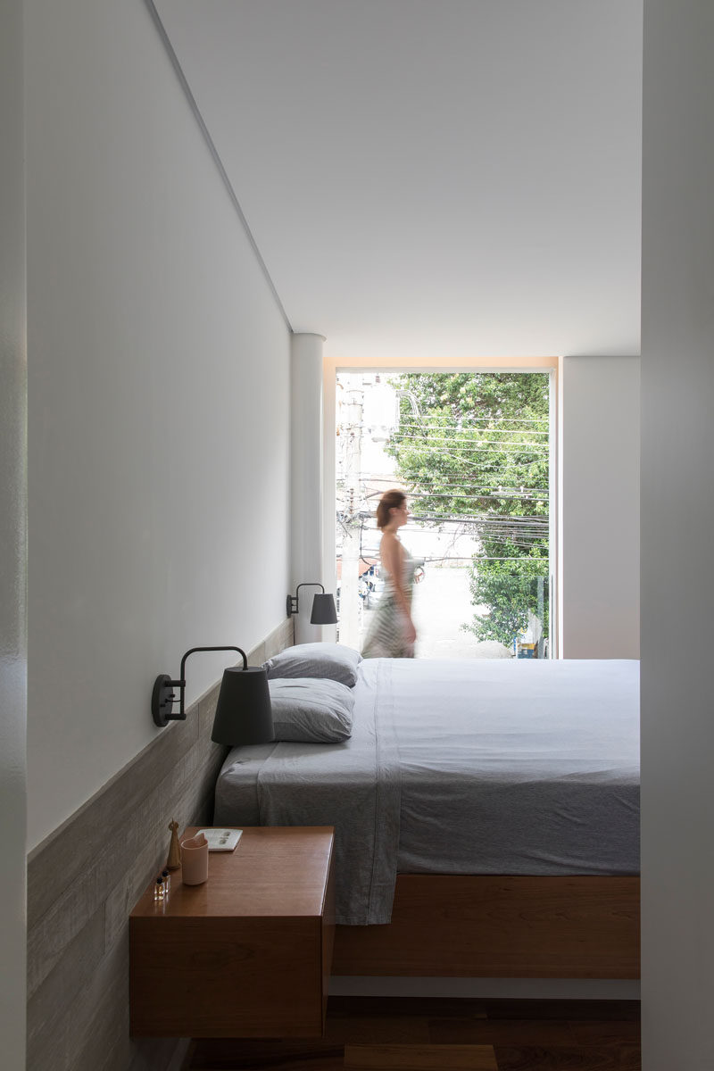 This simple bedroom has a floor-to-ceiling window that overlooks the street. A wood shutter can be closed to provide privacy for the bedroom. #Bedroom #Window