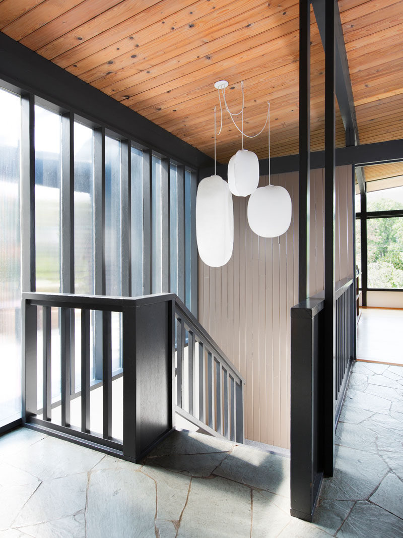 In this mid-century modern remodel, a black staircase leads down to the lower floor of the home. #BlackStairs