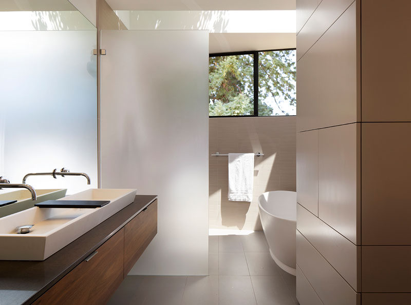 This modern bathroom has a frosted glass frameless shower screen that separates the shower from the vanity. #ModernBathroom