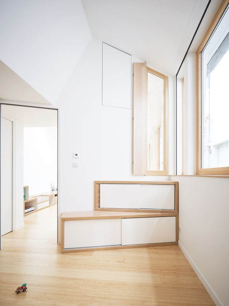  A vertical window provides a view into the kitchen from the bedroom, while below the window, there's storage that neatly fits into the corner. #Storage #Window