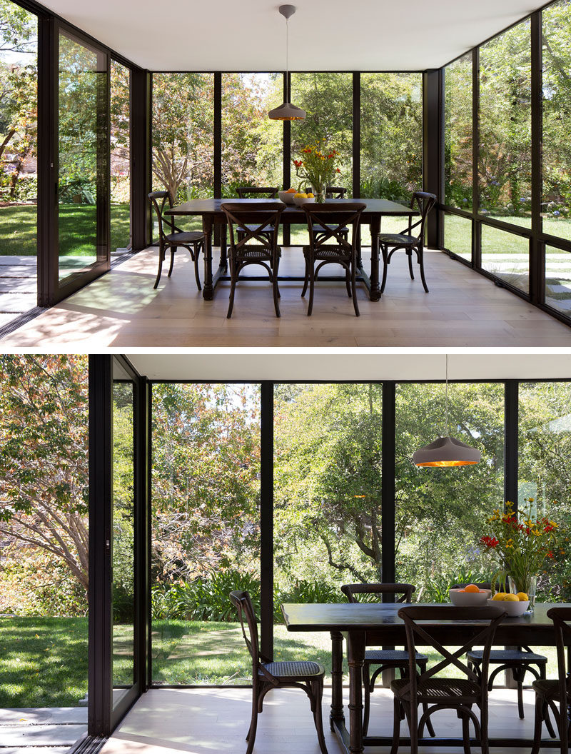 This modern dining room projects into backyard as a glass box surrounded by landscape, creating a space for enjoying time with family and friends and holding impromptu work meetings. #DiningRoom #Windows