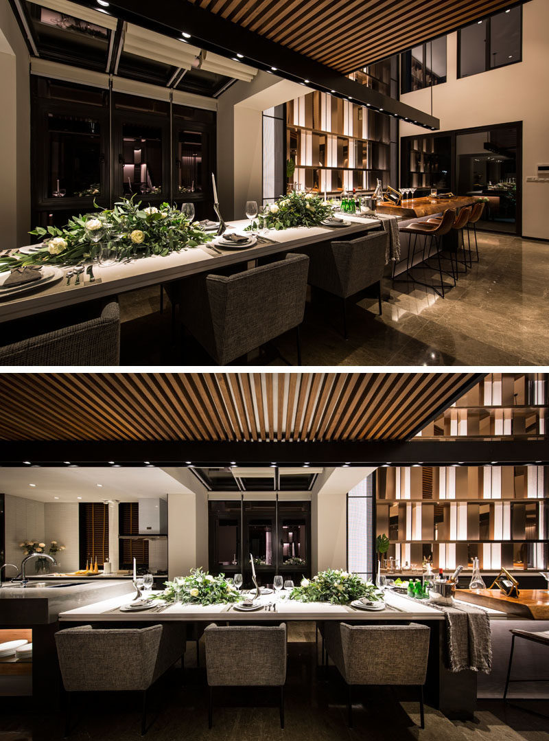 This long and modern kitchen island is home to a bar, a six person dining table and a food prep area. #KitchenIsland #ModernKitchen