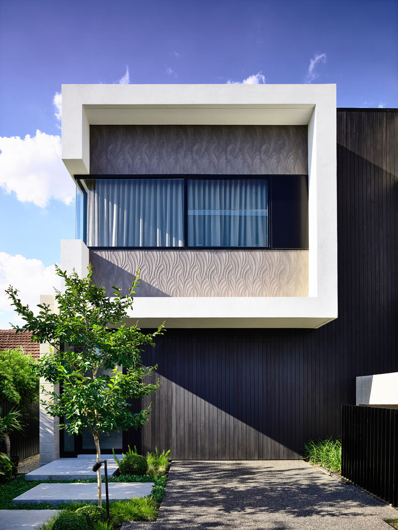 This modern duplex conceals the garages and utility room behind black stained vertical timber cladding #Architecture #HouseDesign #Duplex