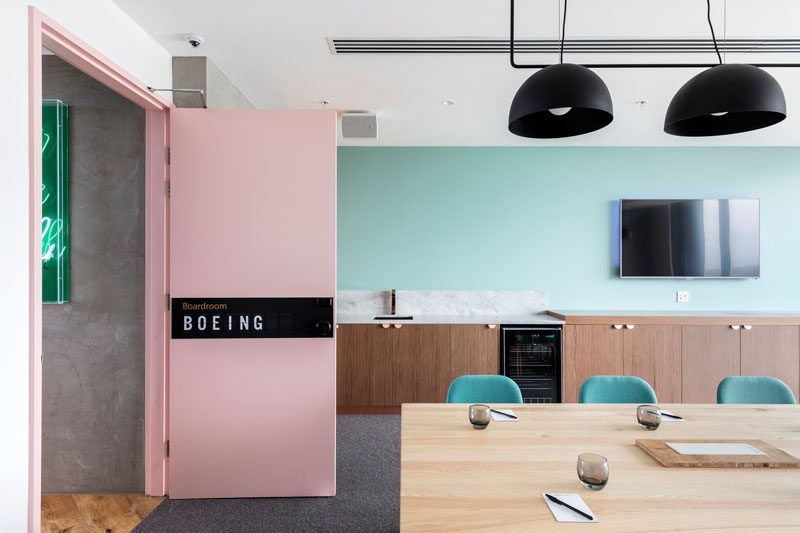 This hotel meeting room has a pale pink door that leads into a space with pastel blue walls and a bar/sideboard/kitchen area. #MeetingRoom #HotelInterior