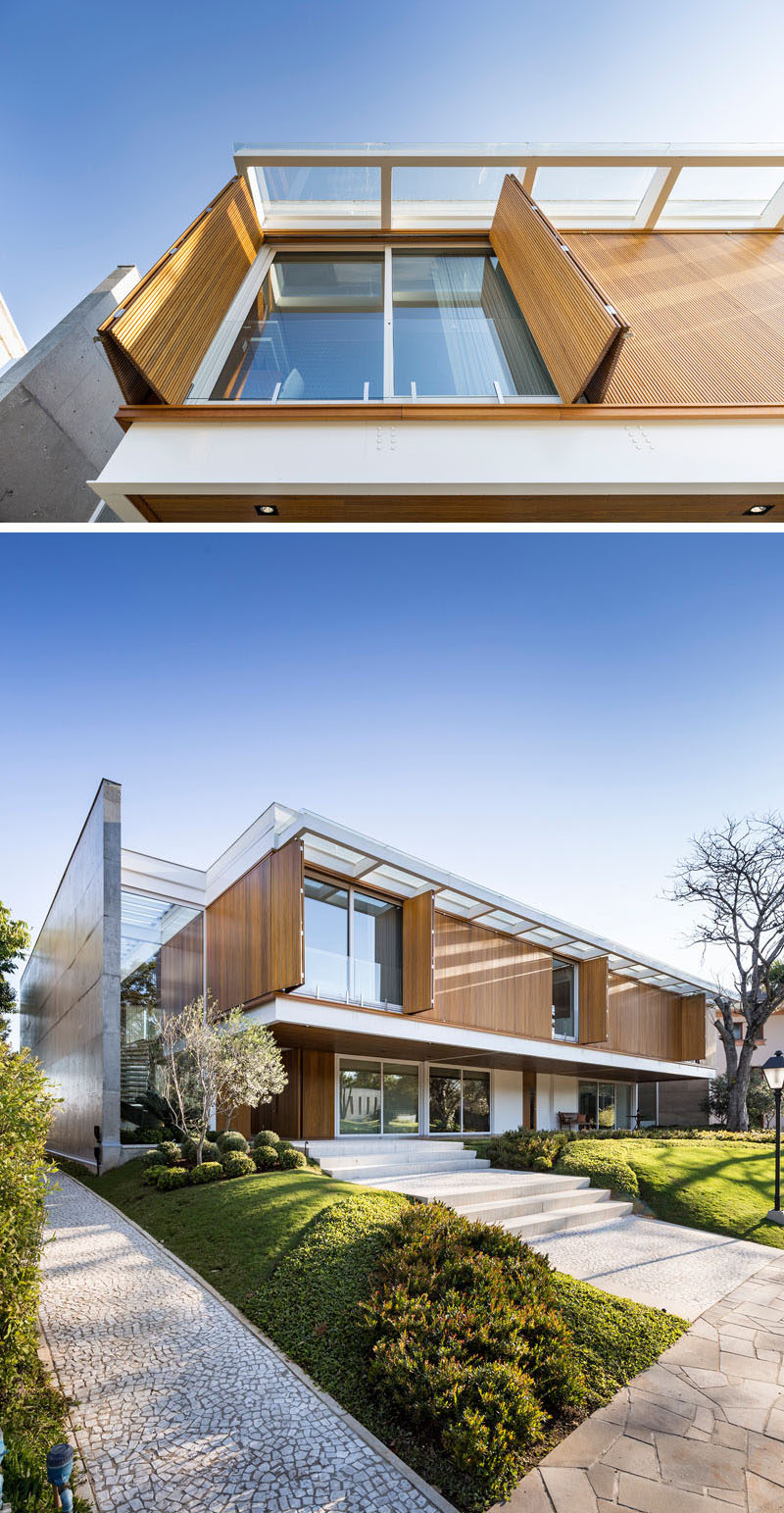 The upper level of this modern house has wood shutters that blend into the facade when closed, and when open, they allow the sunlight to filter through to the interior. #WoodShutters #ModernShutters