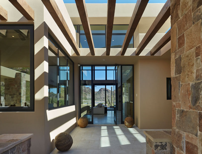 This modern house has a partially covered entryway that leads to the front door. #ModernHouse #Entryway