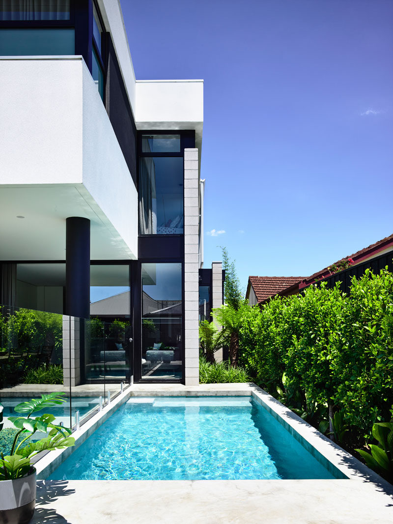 This modern house has a small swimming pool surrounded by lush plants and an alfresco dining area. #SwimmingPool