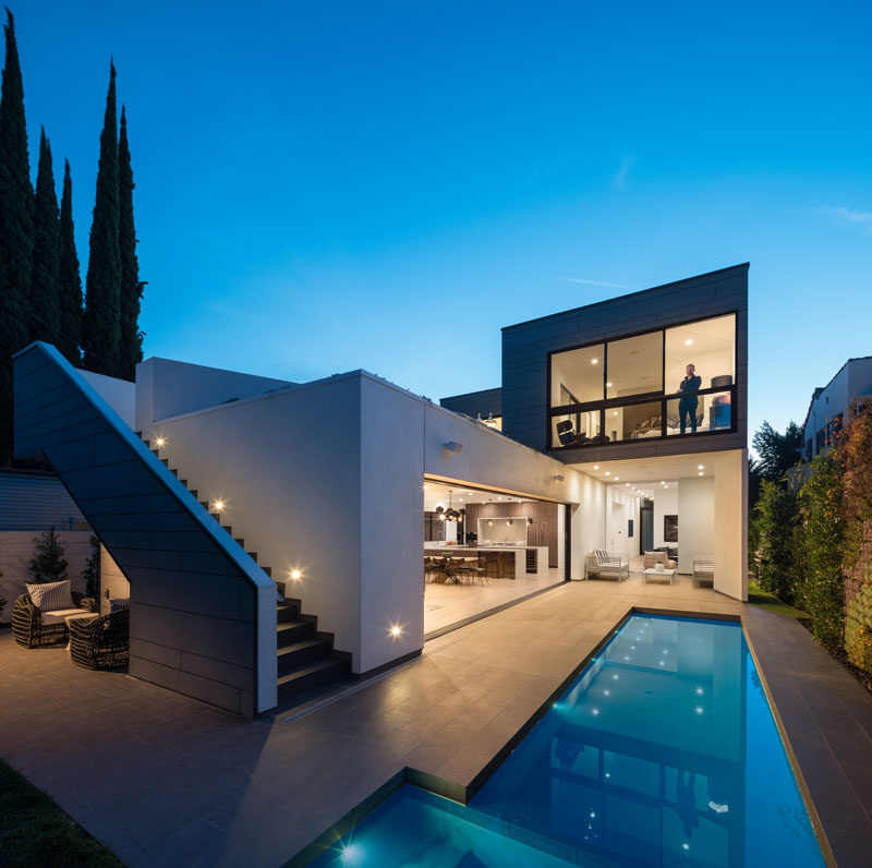 This modern house has an exterior staircase that leads from the backyard up to a rooftop deck. #ExteriorStairs #Staircase