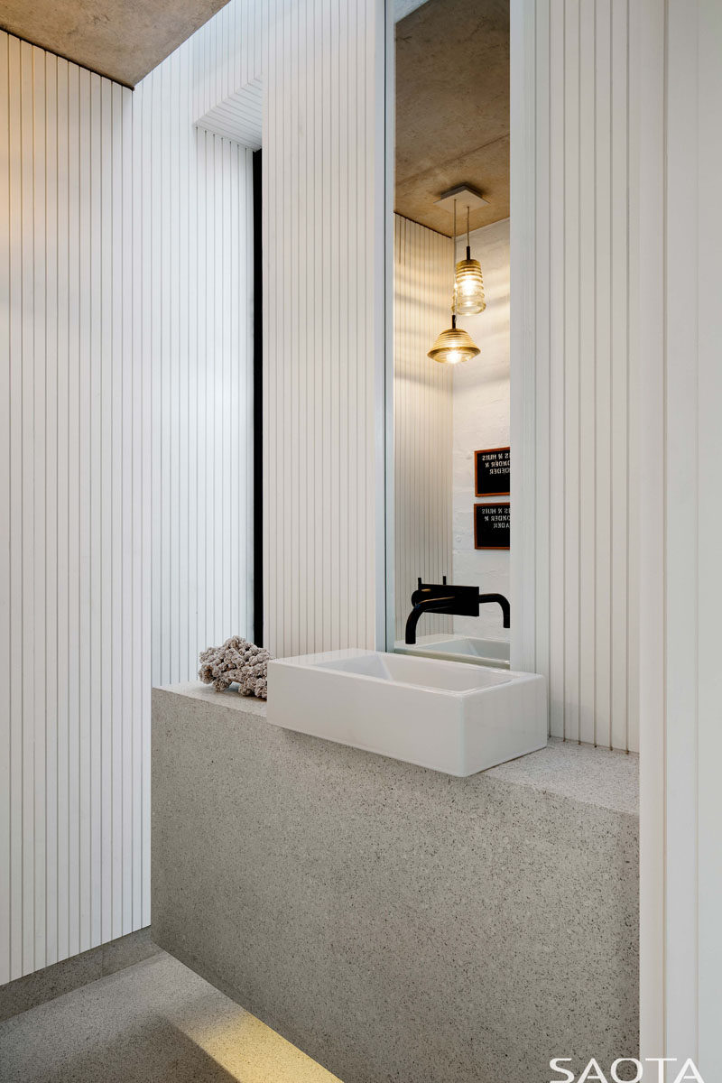 This modern bathroom has been kept bright with the use of textured white walls and a light that's hidden underneath the vanity. #Bathroom #ModernWhiteBathroom