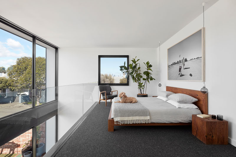 This modern mezzanine bedroom has the city’s skyline is framed perfectly and sits like a picture on the wall, while a glass balcony allows seamless views of the backyard the neighborhood. #MezzanineBedroom #Windows