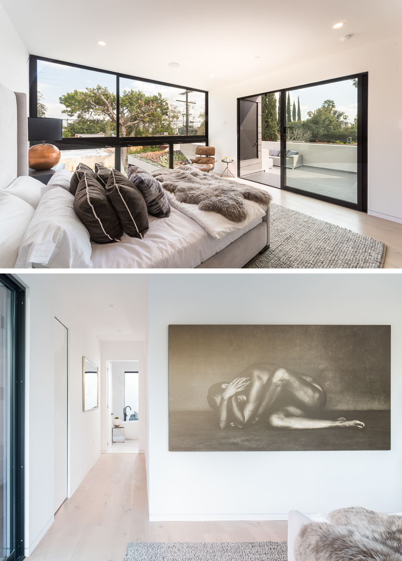 This modern master bedroom suite has a wall of windows that look out to the green roof and pool below. A hallway beside the bedroom leads down to the bathroom. #Modern #MasterBedroom