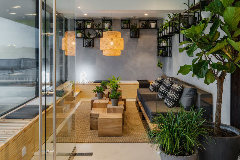 This modern meeting room has a dark couch, a wrap around bench and plenty of plants. #Workplace #MeetingRoom