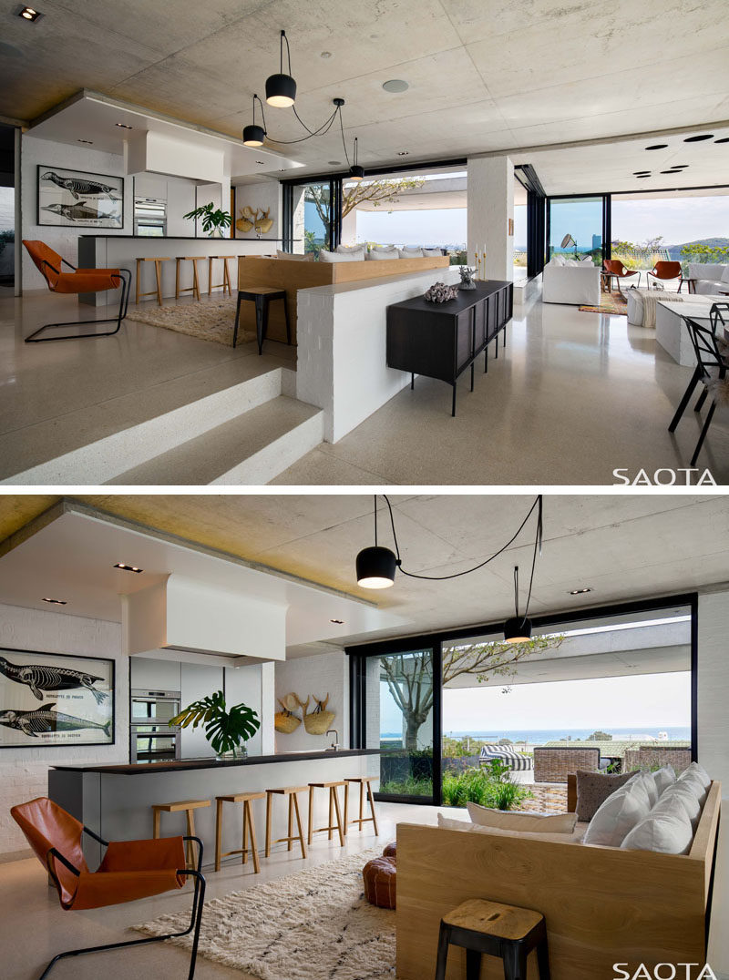 The kitchen and lounge area is at the center of the living space in this modern house, with a sofa in the kitchen large enough to seat the entire family. #ModernKitchen #ModernInterior