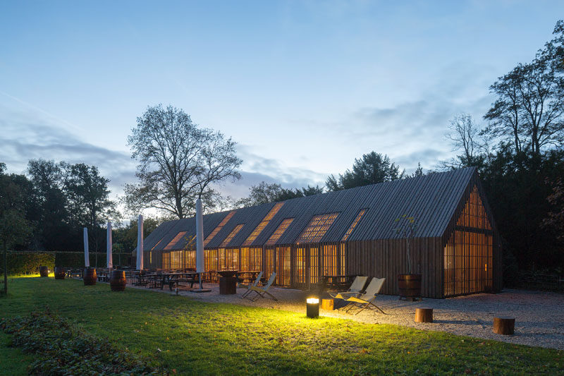 This modern barn-like building nine movable facade parts that open up the building in the morning and close it at night. #Barn #Architecture #BuildingDesign