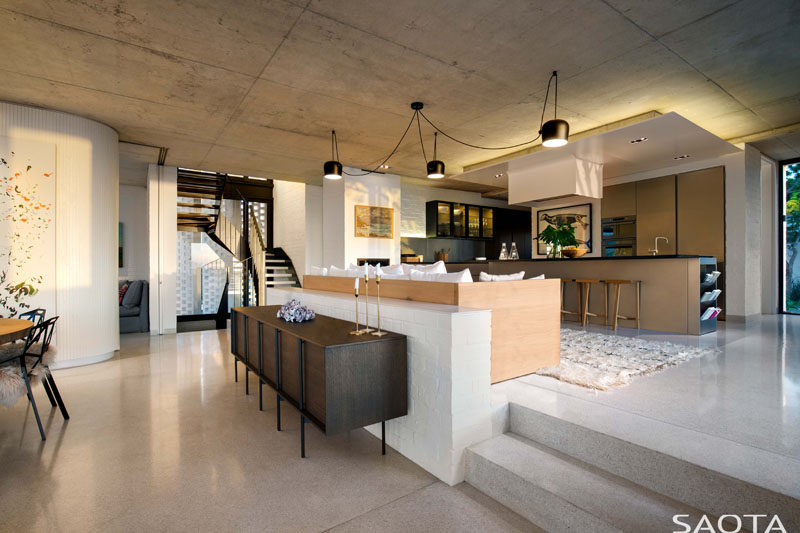 This modern house has a the kitchen and a couch raised up from the dining area. #InteriorDesign #Kitchen