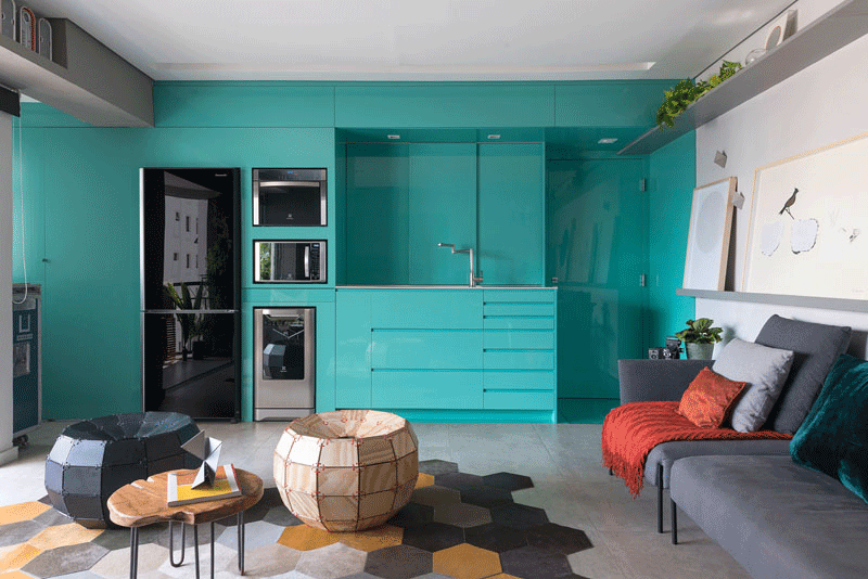 Every space of this modern bright blue kitchen has a designated function, like the washer/dryer hidden away at the end, a pull-out countertop underneath the microwave or the cabinets that provide and abundance of storage. #ModernKitchen #KitchenStorage #KitchenDesign