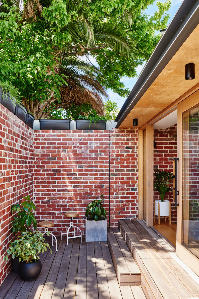 Red brick paving from the backyard has been recycled and now used as an internal feature wall and an external brick wall. #BrickAccentWall #BrickWall #OutdoorSpace