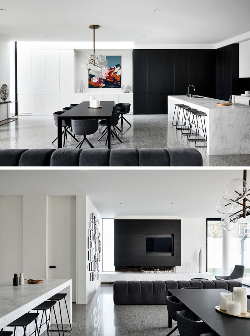 This modern house has an open plan living room, dining room and kitchen, that all follow a black and white color palette. Click through to see more photos of this modern house. #BlackDiningRoom #BlackAndWhite #InteriorDesign #ModernInterior #BlackAccentWall