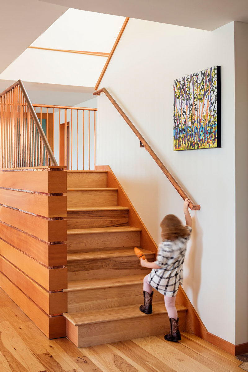 Simple contemporary wood stairs with a wood handrail connects the floors of this house. #WoodStairs