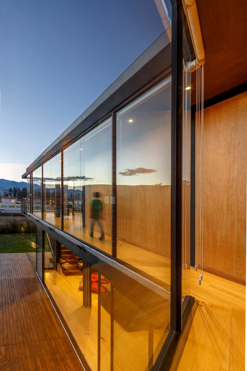 Wood and glass lined hallways in this modern house lead to the bedrooms and bathrooms. #GlassWalls #Hallway