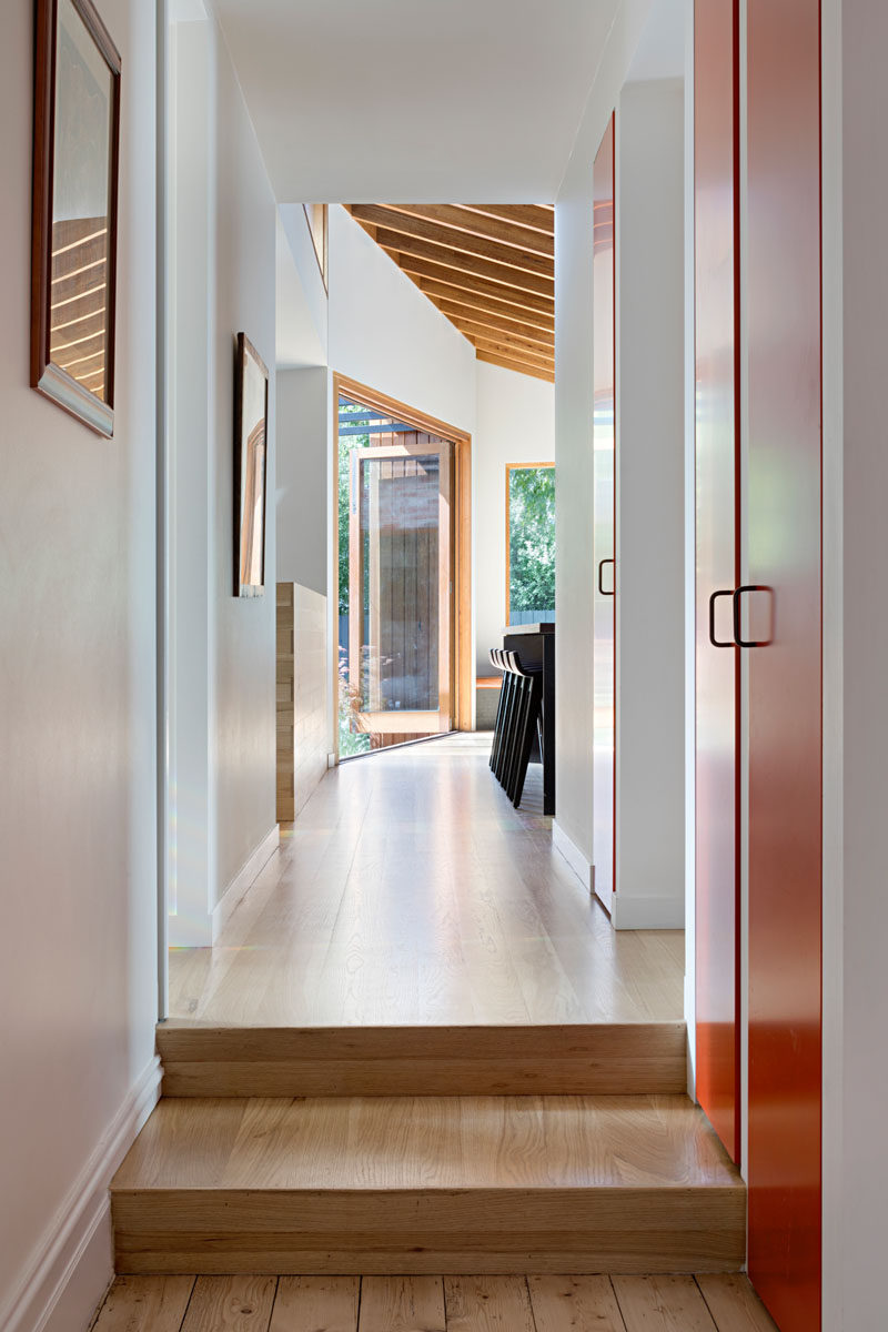 Connecting the original house with the new addition is a hallway with a wood floor that provides access a bathroom and a laundry room. #Hallway #WoodFllor